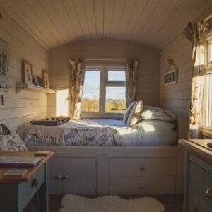 empty bed beside windows during daytime