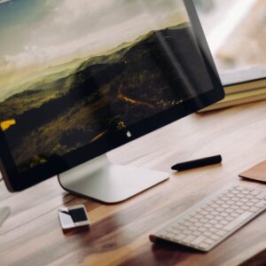 space gray iMac near Magic Keyboard on brown wooden computer desk during daytime