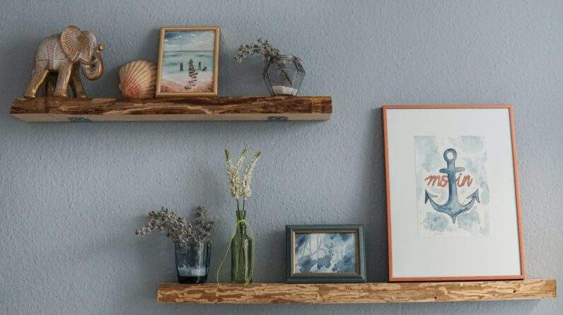 white flowers in clear glass vase on brown wooden wall shelf